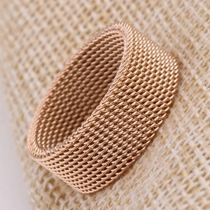 Macro shot of 8mm rose gold woven mesh ring texture on natural burlap background