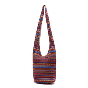 Detailed close-up of bohemian style shoulder bag with colorful woven ethnic pattern texture