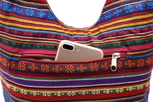 Detail of colorful striped canvas bag showing fabric texture and outer zipper pocket