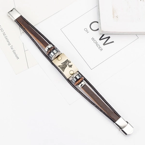 Macro detail of multi-layer brown leather bracelet with Virgo metal plate and steel clasp
