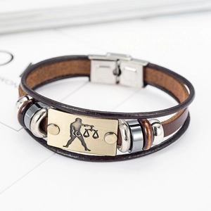 Close-up of vintage brown leather woven bracelet with Libra sign and stainless steel clasp