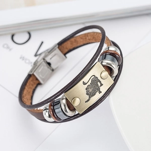 Detail of vintage Leo zodiac leather bracelet with antique bronze charm on white plate
