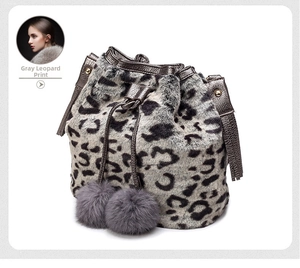 Detail of grey leopard print faux fur bucket bag with drawstrings and fluffy pom-poms