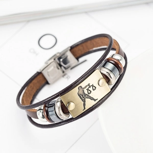 Detail of multilayer leather Libra bracelet featuring vintage bronze zodiac charm and clasp