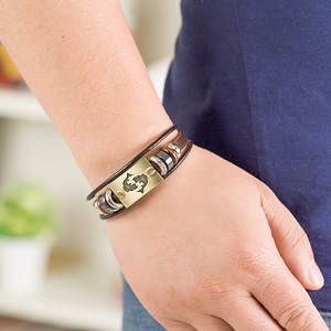 Detail of multi-layer leather bracelet with Pisces zodiac brass plate and vintage beads