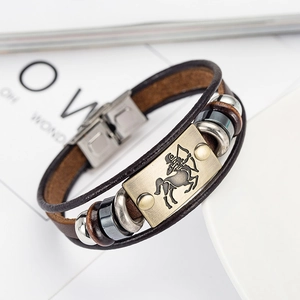 Detailed close-up of a brown leather Sagittarius zodiac bracelet with brass metal plate