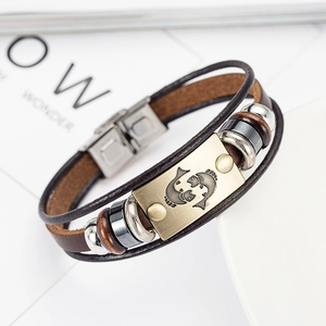 Detail of multi-layer brown leather Pisces bracelet with retro brass zodiac charm
