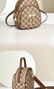 Detail view of mini brown checkered crossbody bag with swan hardware and pearl charms