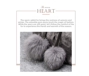 Close-up of grey fluffy faux fur pom-poms on a bucket bag showing soft texture detail