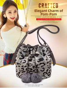 Detail of leopard print faux fur bucket bag with plush pom-poms and leather drawstring strap