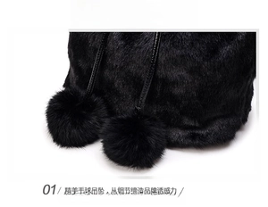 Detail of plush black faux fur handbag featuring soft decorative twin pom-pom charms