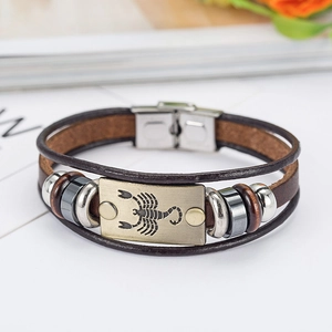 Detail of multi-layer brown leather bracelet with Scorpio zodiac bronze metal plate