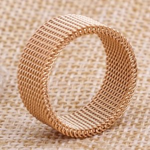 Macro detail of rose gold mesh woven ring texture on rustic burlap background
