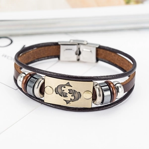 Macro view of brown leather zodiac bracelet with bronze Pisces plate and metal beads