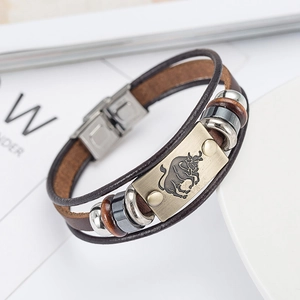Detail of Taurus zodiac bracelet featuring braided leather and bronze metallic charm