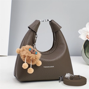 Dark brown lychee pattern leather handbag with plush charm and adjustable shoulder strap