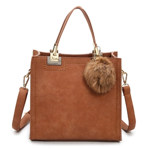 Brown matte square tote bag with plush ball charm and gold metal hardware detailing