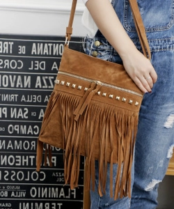 Close-up of brown suede crossbody bag featuring long fringes and metallic stud details