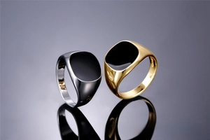 Close-up of classic gold and silver men's rings with black enamel square top