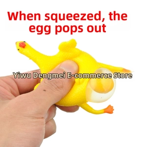 Close-up of hand squeezing yellow rubber chicken toy to reveal a popping egg yolk effect
