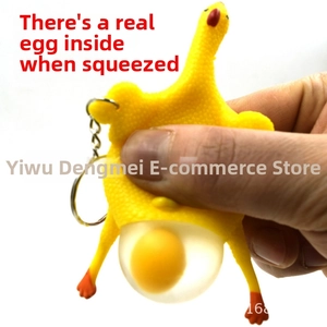 Detailed close-up of novelty rubber chicken toy squeezing out a simulated egg