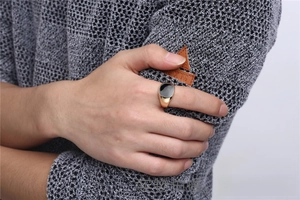 Detailed close-up of a classic gold-toned men's signet ring with black enamel inlay.