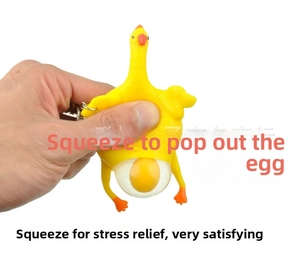 Close-up of hand squeezing yellow chicken stress relief toy showing popping egg effect