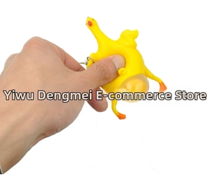 Close-up of hand squeezing the yellow rubber chicken keychain to show the egg popping effect