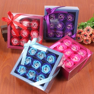 Close-up of four colorful soap flower gift boxes with 9 roses each on a wooden table