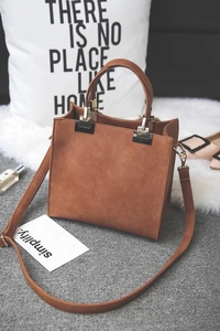 Detailed view of a brown PU leather crossbody bag with gold hardware and strap