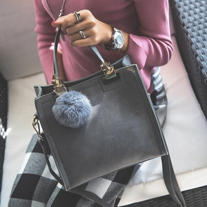 Dark gray frosted crossbody handbag with golden hardware and fluffy pompom detail