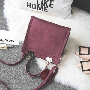 Deep red frosted square handbag with plush pom-pom charm and golden buckle detail