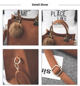 Close-up of brown matte tote bag featuring gold hardware and a soft pom-pom charm detail