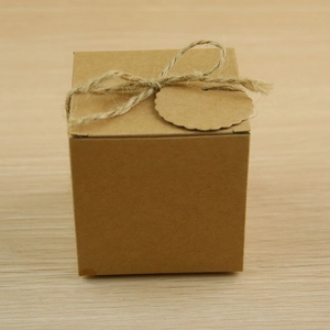 Detail of square kraft paper gift box with rustic twine bow and wavy edge tag
