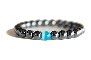 Detail of dark grey hematite beads bracelet with a blue cat-eye stone focal point