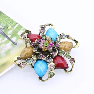 Detailed macro view of vintage flower brooch with multicolored resin gems and rhinestones