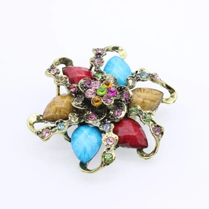Vintage flower brooch with teardrop gemstones and colorful rhinestones on bronze metal base