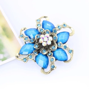 Macro detail of vintage floral brooch with blue resin gems and sparkling rhinestones