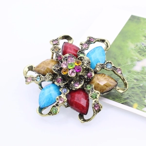 Close-up of vintage floral brooch with colorful resin gemstones and sparkling rhinestones