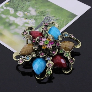 Close-up of vintage flower brooch with colorful resin gemstones and rhinestones