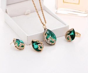 Detailed view of green crystal teardrop jewelry set with necklace and ring on display