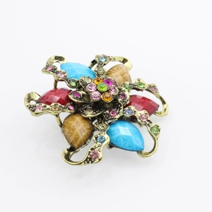 Close-up of vintage flower brooch with teardrop resin stones and colorful rhinestones