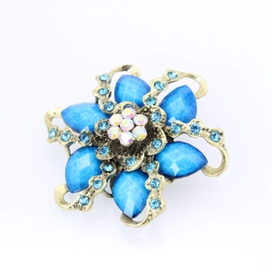 Detail shot of vintage bronze flower brooch with blue resin gems and sparkling rhinestones