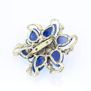 Detailed back view of flower brooch showing blue resin petals and gold metal clasp