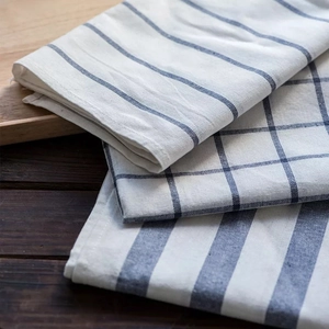 Detailed view of layered cotton linen napkins with blue stripes and grid patterns