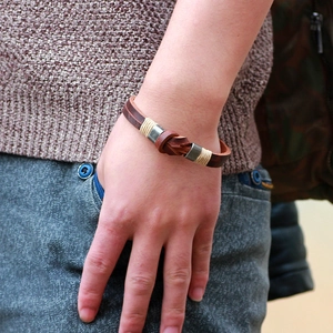 Handmade brown braided leather bracelet with vintage knot design on male model wrist