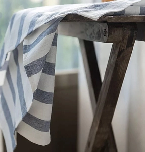 Detail of blue and white striped cotton napkin with soft hanging texture and linen feel