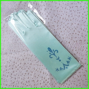 Détail macro de gants de princesse en satin bleu avec emblème de couronne et paillettes