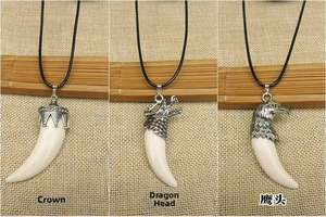 Three pendant styles showing crown, dragon, and eagle silver caps on white resin wolf fangs