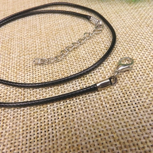 Detail of adjustable black braided necklace cord with silver alloy lobster clasp and chain